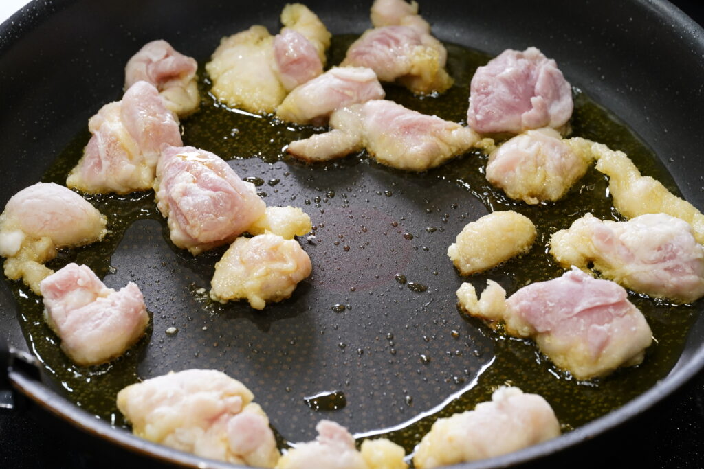 鶏肉をオリーブオイルで揚げる写真