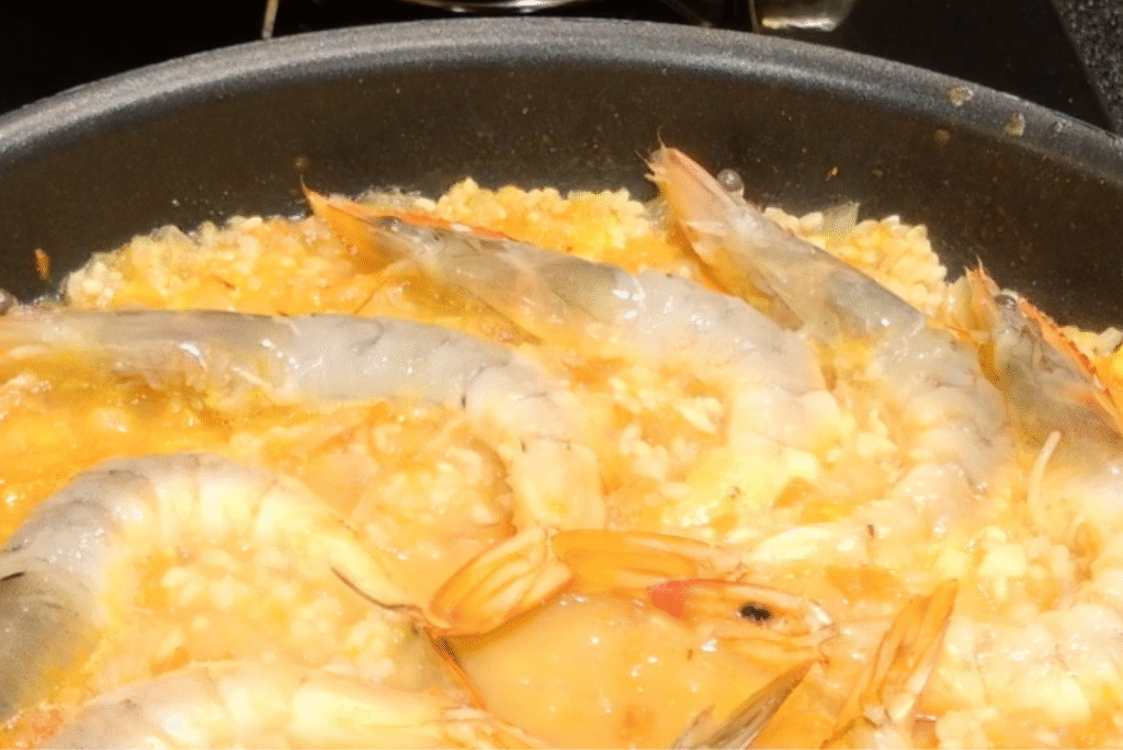 パエリアにエビをのせる写真