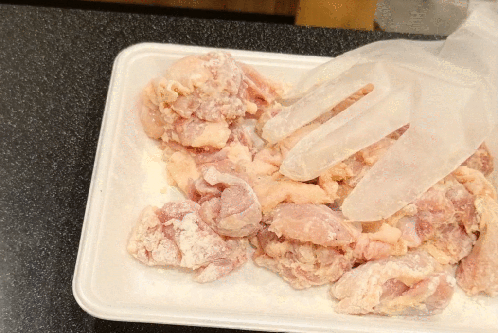 鶏肉に調味料を揉みこむ写真